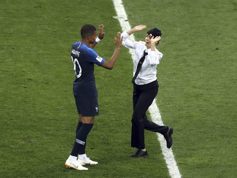 The most iconic image of the World Cup - France's Kylian Mbappé high fiving a member of Pussy Riot after she broke onto the pitch to protest political oppression in Russia   